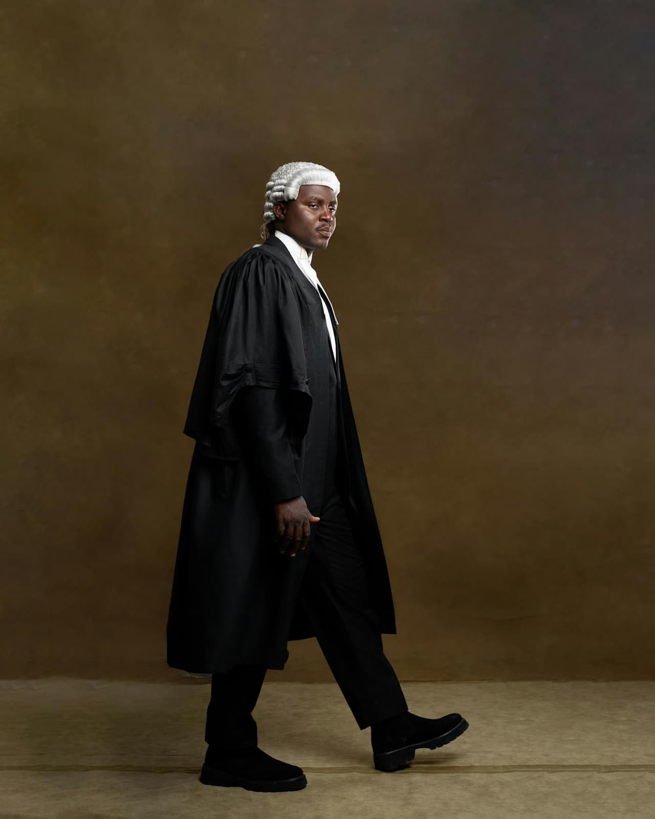 Confident barrister wearing traditional wig and gown, symbolising legal authority and expertise.